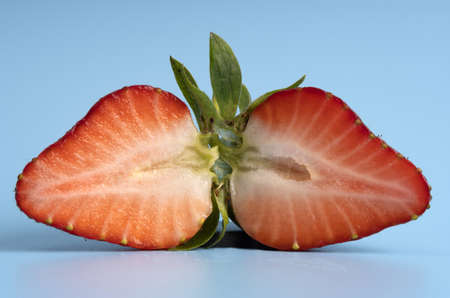 two halves of ripe strawberrÑƒ, front view.