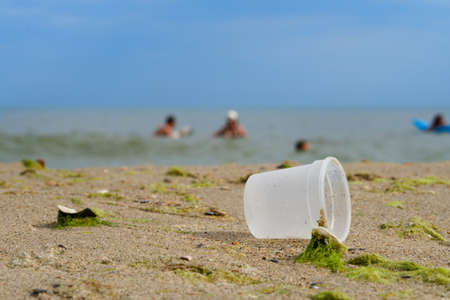 Plastic cup near the sea, blurred background, selective focus.の写真素材