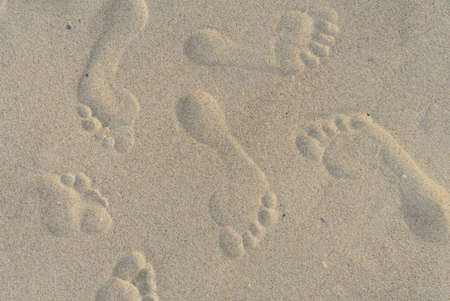 footprints of bare feet on the sand top view.の写真素材