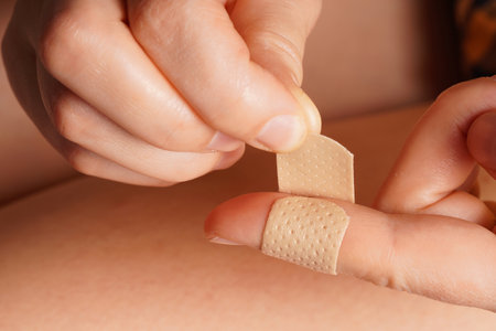 a girl puts a medical plaster on her finger.