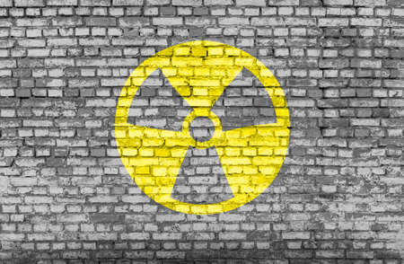 Nuclear danger yellow symbol painted on a brick wall.の写真素材