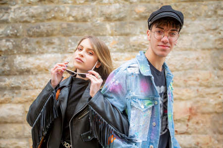 Young students are a italian woman and man whit glass that walking in the street of medieval historic center of an Apulian city of Molfetta in Pugliaの写真素材