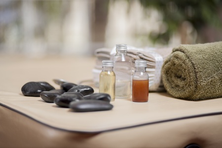 Stones, oil, towels, and bed in place at a health and beauty spaの写真素材