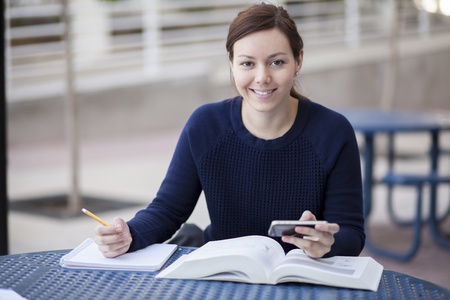 Beautiful woman doing homework at schoolの写真素材