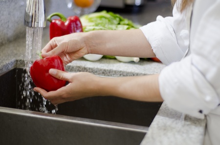 Closeup of chef s hands washing some vegetables in the sinkの写真素材