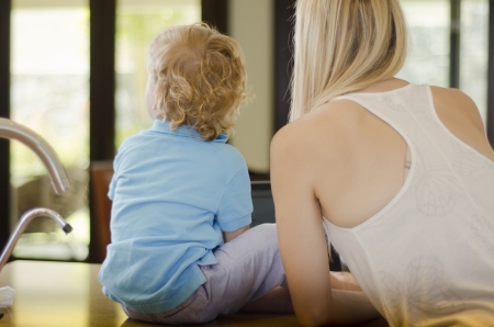 Blond mom and son spending time together and looking at somethingの写真素材
