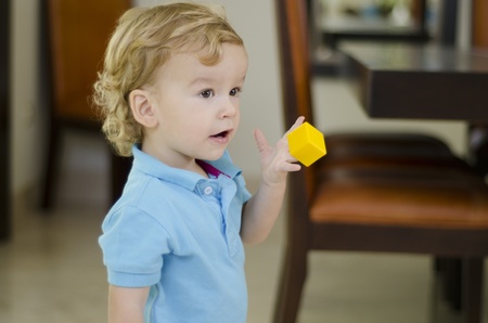 Cute boy holding a piece to a puzzle and showing it to someoneの写真素材