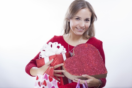 Beautiful young woman carrying tons of gift boxes for valentine s dayの写真素材