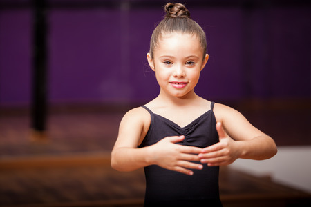 Portrait of a cute little girl practicing a dance pose in a dance academyの写真素材