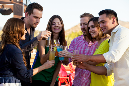 Group of friends having fun and making a toast at a barの写真素材
