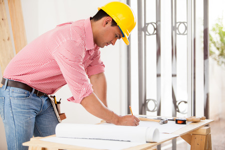 Handsome Hispanic engineer doing some design work and remodeling a houseの写真素材