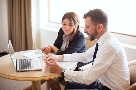 Couple of business partners working together and reviewing some documents in a hotel