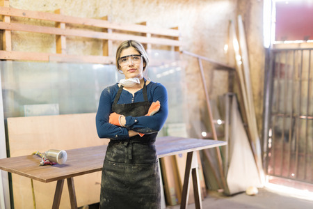 Good looking young confident woman working as carpenter in her own woodshopの写真素材