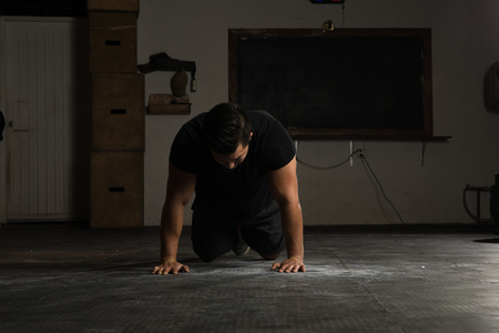 Portrait of a young man lying on the floor exhausted after finishing his workout in a cross-training gymの写真素材
