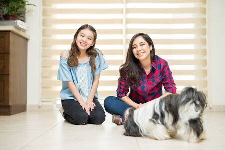 Portrait of a good looking young woman relaxing and having a good time with her daughter and her little dogの写真素材