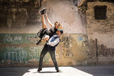 Full length view of a couple of young dancers performing together in an urban setting outdoorsの写真素材