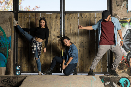 Three young Hispanic dancers showing some of their dance moves in an abandoned buildingの写真素材