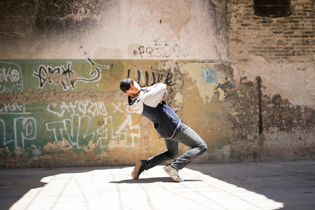 Portrait of a good looking Hispanic male dancer freestyling outdoors in an abandoned buildingの写真素材
