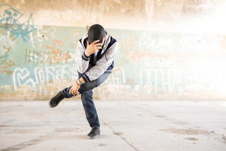 Full length view of a young male urban dancer performing a dance routine in an abandoned building. Plenty of copy spaceの写真素材