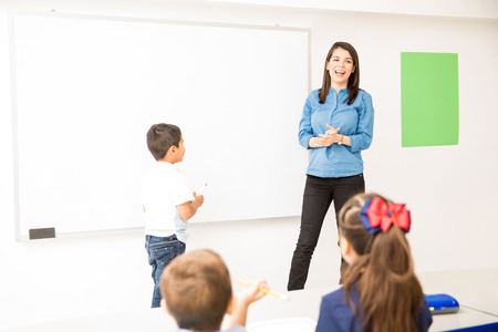 Little boy ready to draw on the board while playing a game in a preschool classroomの写真素材