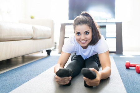 Portrait of good looking young woman doing yoga in living room