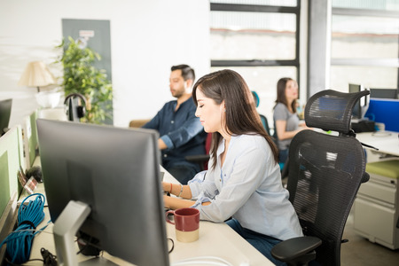 Good looking young woman working on laptop at her deskの写真素材