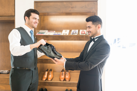 Man in formals selecting best shoes for his marriage in storeの写真素材