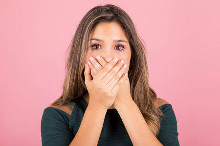 Woman in disbelief covering her mouth with both the hands