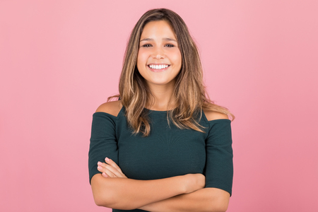 Happy young woman keeping her confidence strong in pink studioの写真素材