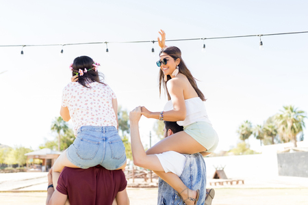 Young woman dancing while enjoying music festival with best friendsの写真素材