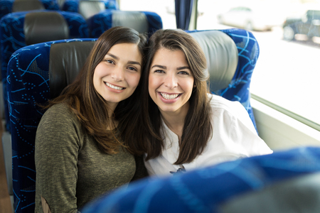 Attractive brunette women enjoying city tour in luxury busの写真素材