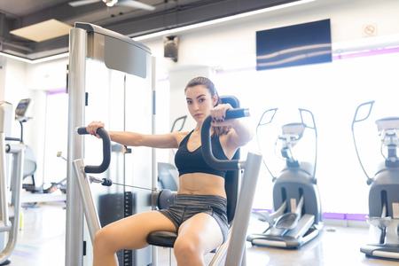 Portrait of strong athlete building pectoral muscles with the help of chest-press machine