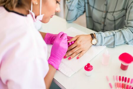High angle view of nail technician applying polish on customer's hands at spaの写真素材