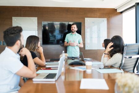 Good looking businessman leading meeting with his colleagues in officeの写真素材