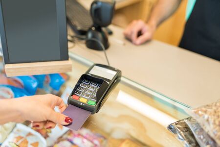 Cropped image of woman paying through credit card in grocery store