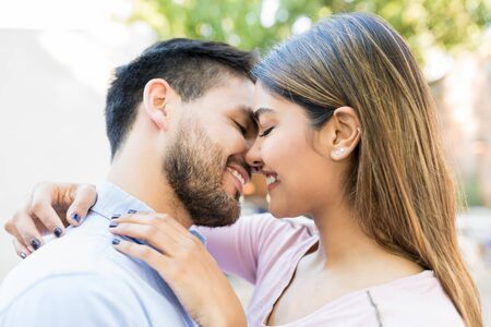 Closeup of smiling boyfriend and girlfriend kissing