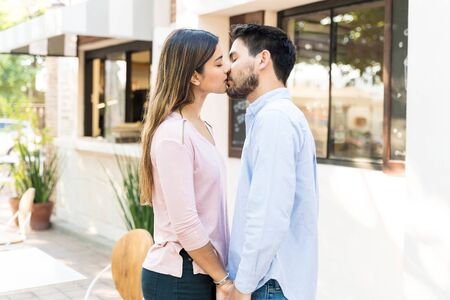 Side view of romantic boyfriend and girlfriend kissing during date