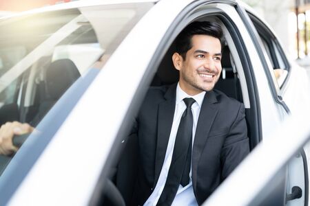 Confident good looking young Hispanic businessman in car