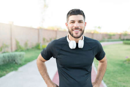 Portrait of smiling sporty Latin young man working out in park