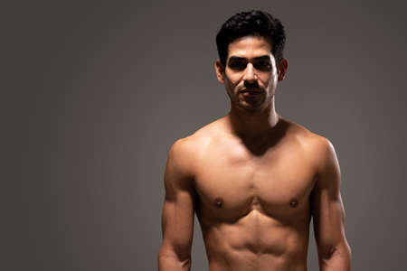 Hispanic male athlete with ripped body isolated over gray backgroundの写真素材