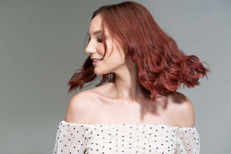 Closeup of young female fashion model with redhead tossing her hairの写真素材