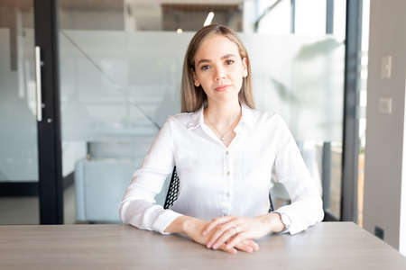 Portrait of a businesswoman sitting at office conference room table looking at cameraの写真素材