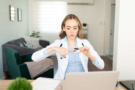 Beautiful female doctor giving some advice on proper use of an oximeter to her online audience on a...