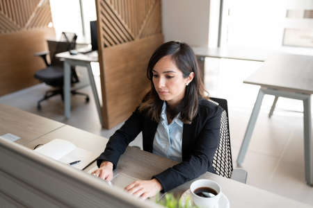 Beautiful caucasian businesswoman sitting at her office desk working on laptop