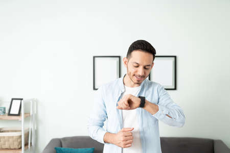 Attractive man talking to his smartwatch and controlling his smart home with it