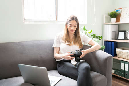 Good looking freelance photographer reviewing photos from a recent shoot and working at home