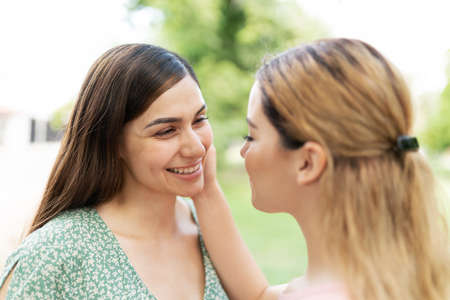 LGBT couple in love looking happy with a caucasian young woman caressing the face of her girlfriendの写真素材