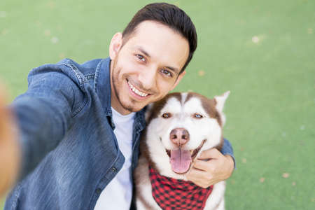 Personal perspective of a selfie taken by adult latin man and his smiling cute dog