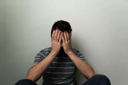 Adult latin man with a lot of stress and problems feeling lonely and miserable. Hispanic man...
