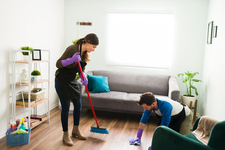 Full length view of a young couple sweeping and wiping the floor together while doing all the house workの写真素材